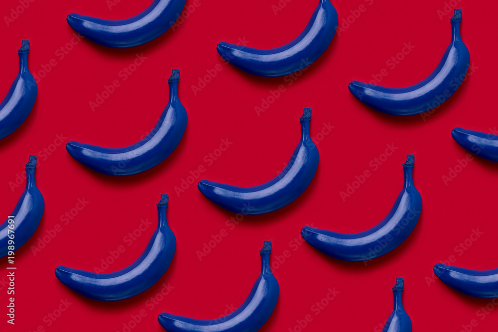 Colorful fruit pattern of fresh blue bananas on red background. From top view Colorful fruit pattern of fresh blue bananas on red background. From top view