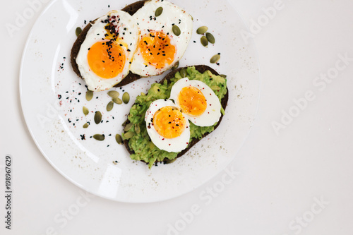 sandwich with fresh vegetables, avocado, hard-boiled eggs and pumpkin seeds with olive oil and bread. healthy diet or vegetarian food on a white background. salad with yolks on toast. top view
