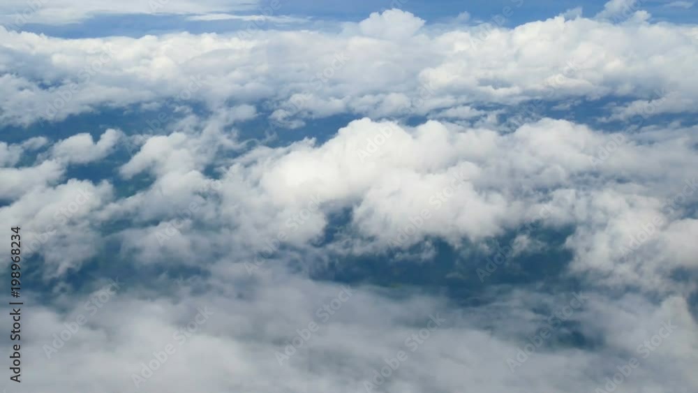 4K. aerial view through an airplane window. beautiful white clouds in blue sky background. traveling by air. 4K. aerial view through an airplane window. beautiful white clouds in blue sky background. traveling by air.