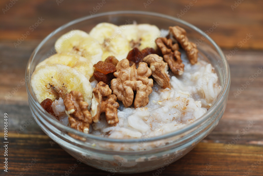 Breakfast with Granola Bowl, Muesli with Oats, Nuts and Dried Fruit, Milk, on Wooden table. Bannana, nuts, fruits. Healthy Breakfast. Diet. Breakfast with Granola Bowl, Muesli with Oats, Nuts and Dried Fruit, Milk, on Wooden table. Bannana, nuts, fruits. Healthy Breakfast. Diet.