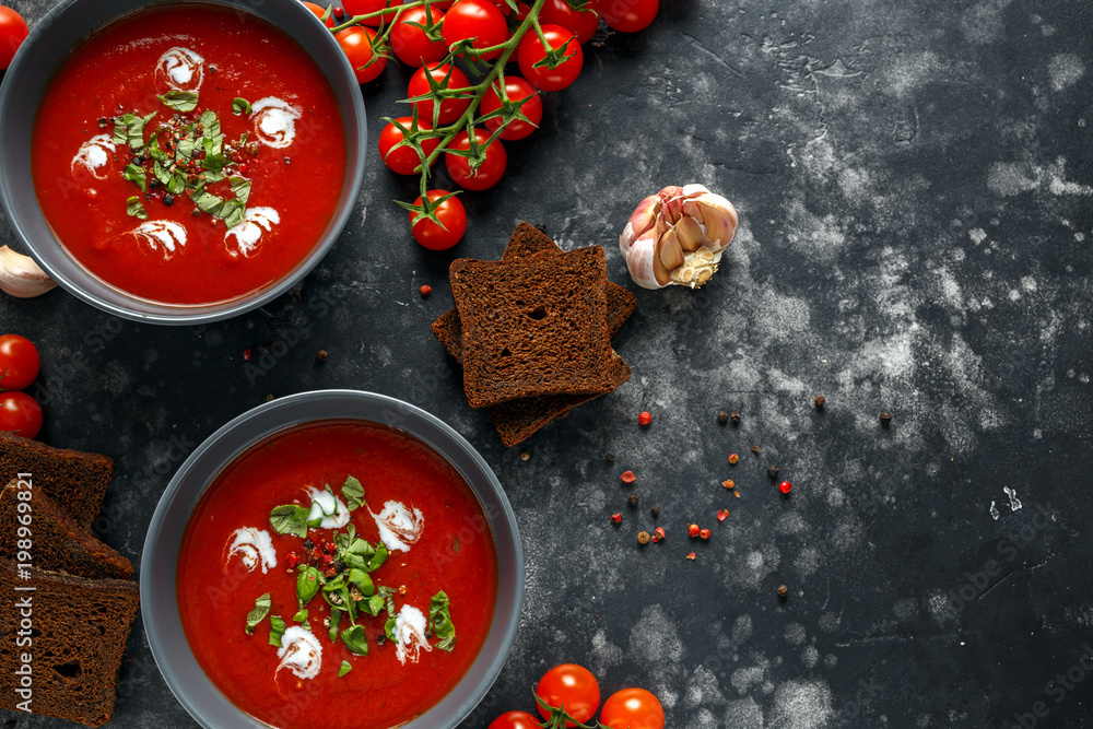 Tomato and fresh basil soup with garlic, cracked papper corns, served with cream and sourdough bread Tomato and fresh basil soup with garlic, cracked papper corns, served with cream and sourdough bread