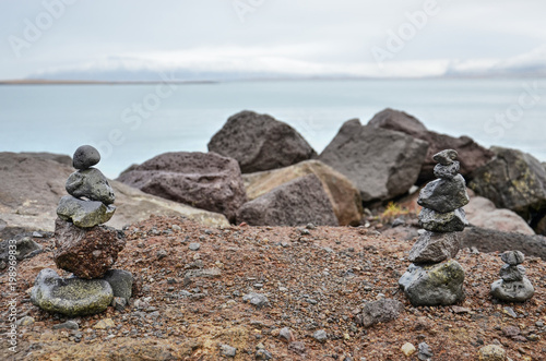 Several small cairns on Saebraut road in Reykjavik, overlooking the bay and the snowy mountains beyond