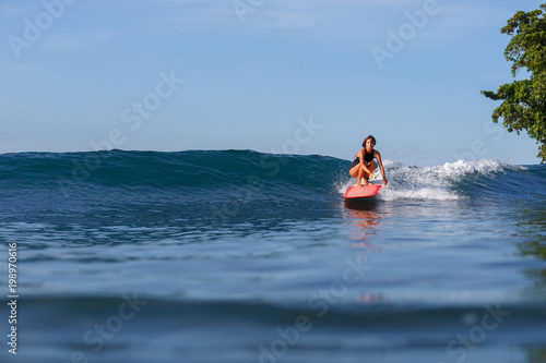 young sporty woman surfing in ocean