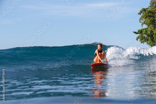 young sportswoman having fun and surfing in ocean