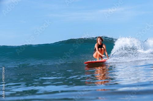 beautiful young girl surfing in ocean