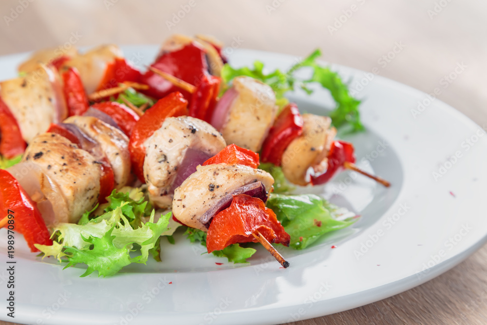 chicken fillet kebabs with roasted peppers, onions and lettuce on wooden skewers are on the plate chicken fillet kebabs with roasted peppers, onions and lettuce on wooden skewers are on the plate