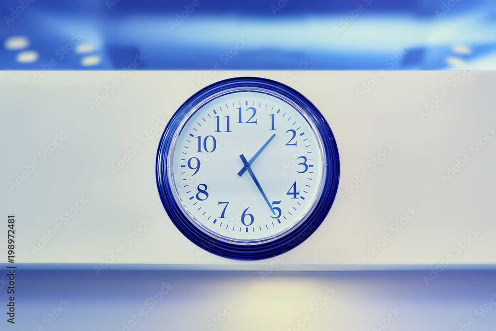 Classic round wall clock, round watch with black arrows hanging on the wall.on office wall background. Classic round wall clock, round watch with black arrows hanging on the wall.on office wall background.