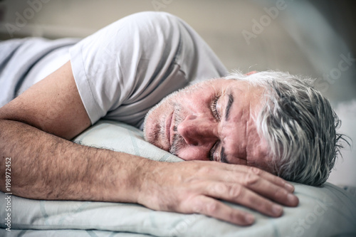Cuadro en lienzo Sleepy senior man in bed.