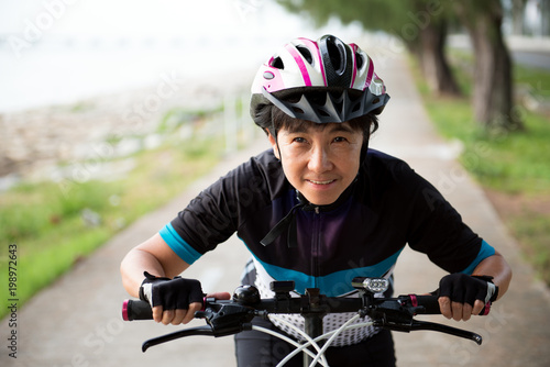 Joyful senior Asian woman riding a bicycle