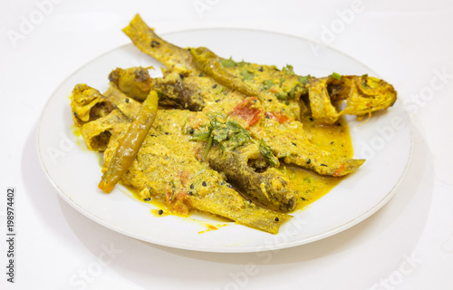 Spicy Parshe fish masala curry garnished with coriander and green chili. Parshe fish is a popular non vegetarian diet in West Bengal, India. Photograph shot in selective focus. photo