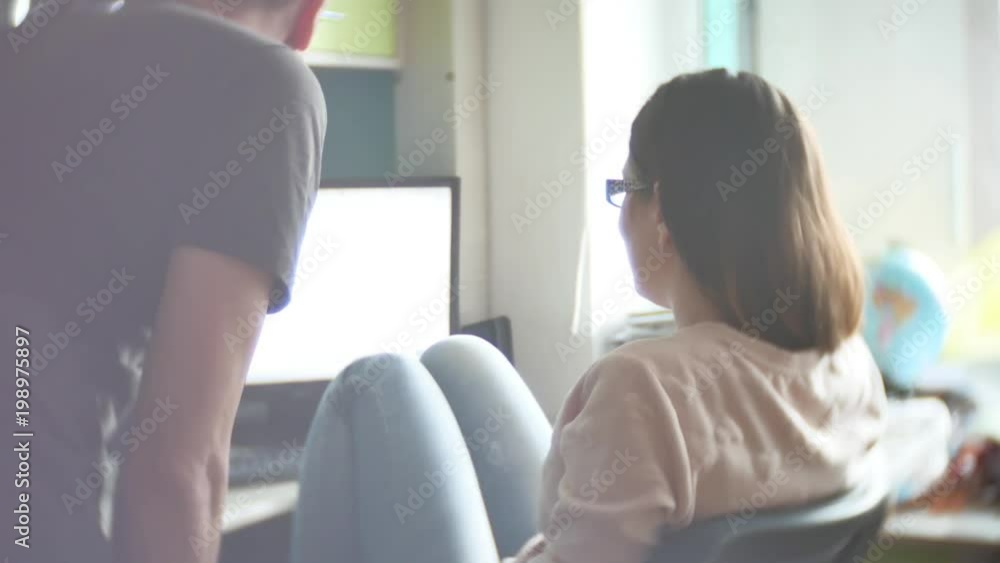 Concentrated couple of young colleagues working in modern office. Two coworkers discussing their work, working with documents. man and woman working in the office at the computer free form of clothing Concentrated couple of young colleagues working in modern office. Two coworkers discussing their work, working with documents. man and woman working in the office at the computer free form of clothing