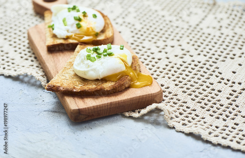 Tasty poached egg on toast over rustic background