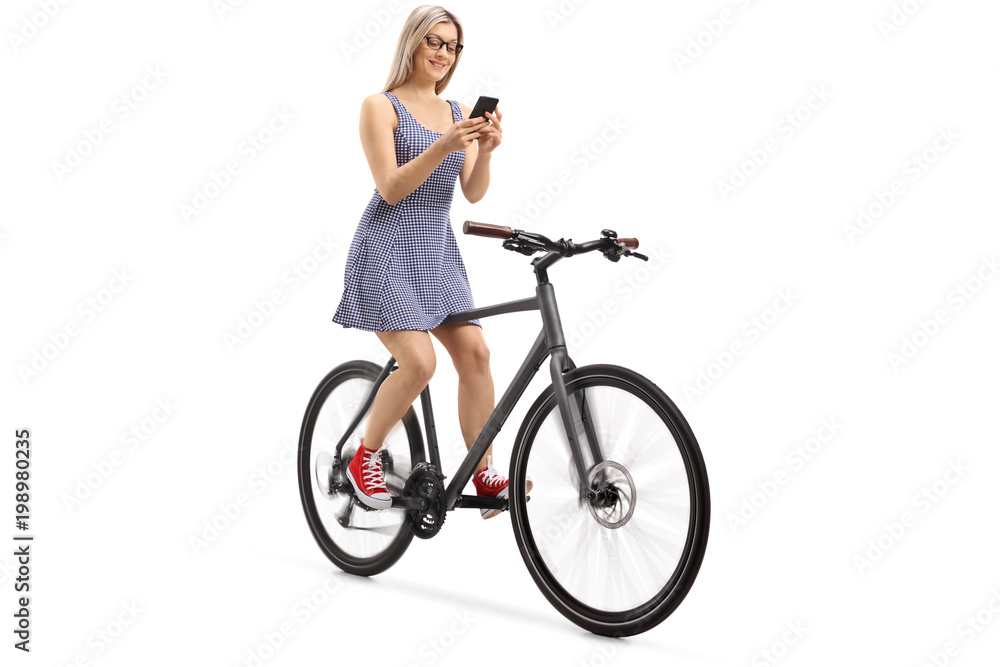 Young woman using a phone and riding a bike Young woman using a phone and riding a bike