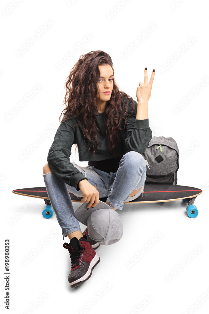 Ταπετσαρία Teenage skater girl seated on a longboard making a peace gesture