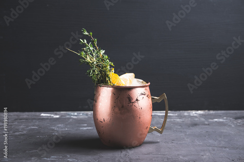 Photography Cold orange Moscow mule cocktail in copper mug. Selective focus.