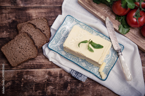 Natural organic fresh ingredients for any food cooking as butter, tomatoes, green coriander on wooden background