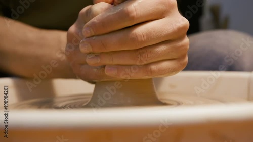 Handicraftsman create product on the circle potterswheel close up isolated. Artisan dexterity and skilfully sculpt traditional culture brown vase or cup. The creativity leisure, creating job of artist photo