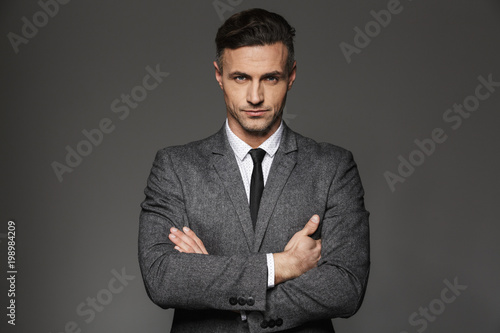 Fotografia Image of mature unshaved man wearing business suit looking on camera with strict