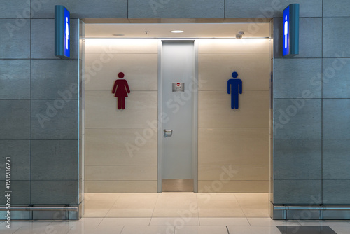 Front view of public restroom or toilet with man and women signs on marble wall. Way to clean restoom man and women toilet sign. photo