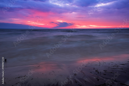 Beautiful twilight landscape. A long exposure of a sunrise or sunset and soft waves washing up the beach.