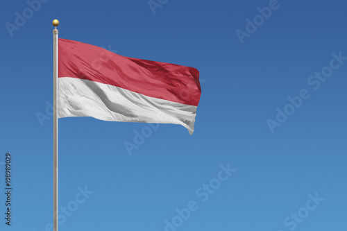 Flag of Indonesia in front of a clear blue sky