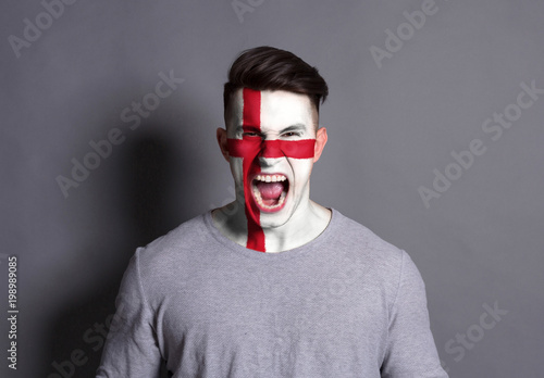 Young man with England flag painted on his face