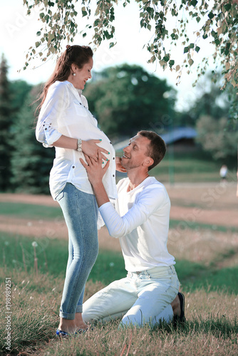 happy husband embracing his pregnant wife on a walk in the Park 