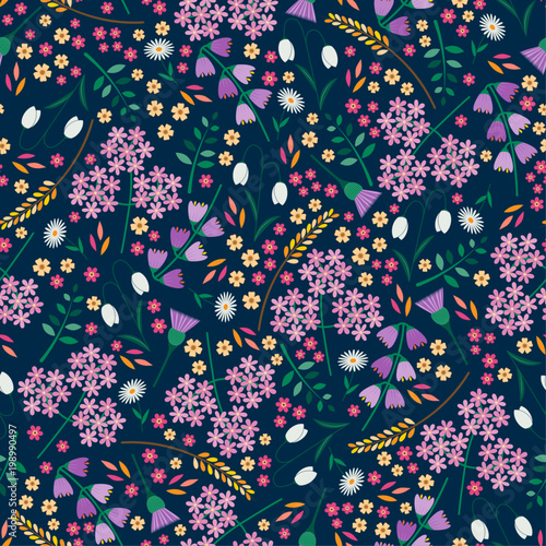 Seamless tossed floral pattern with snowdrops, daisies, angelica, bluebells and thistles on a dark blue background