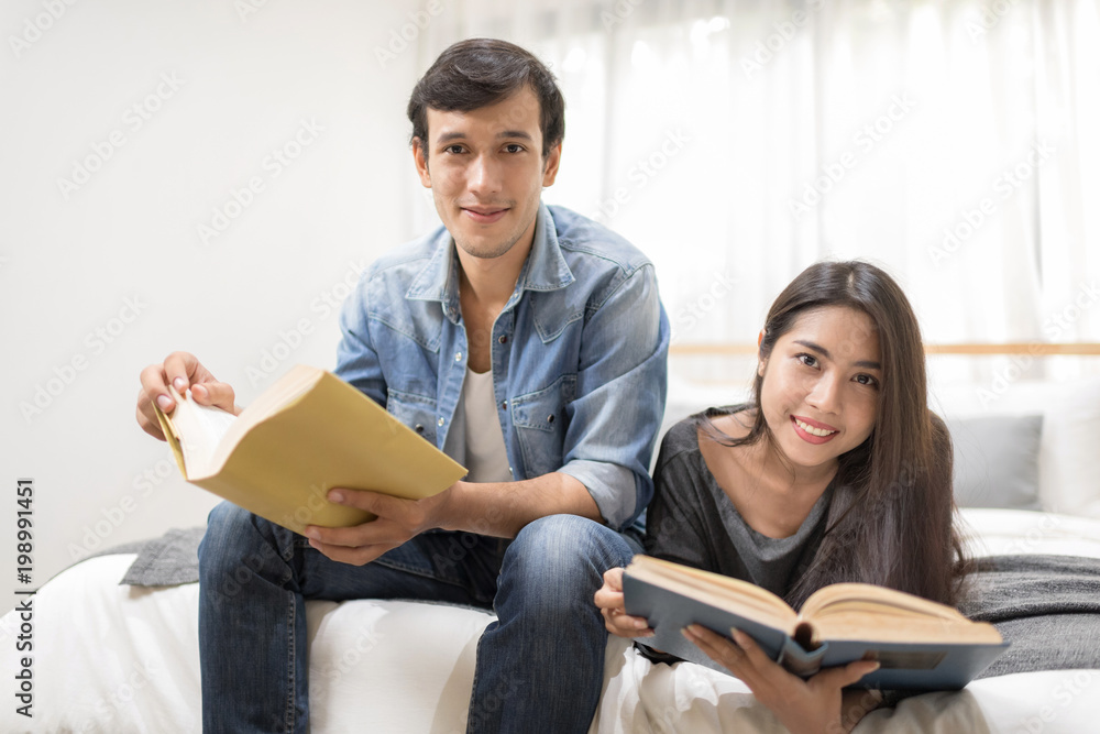 Young couple relaxing at home reading story for going online with using laptop computer on bed. Young couple relaxing at home reading story for going online with using laptop computer on bed.