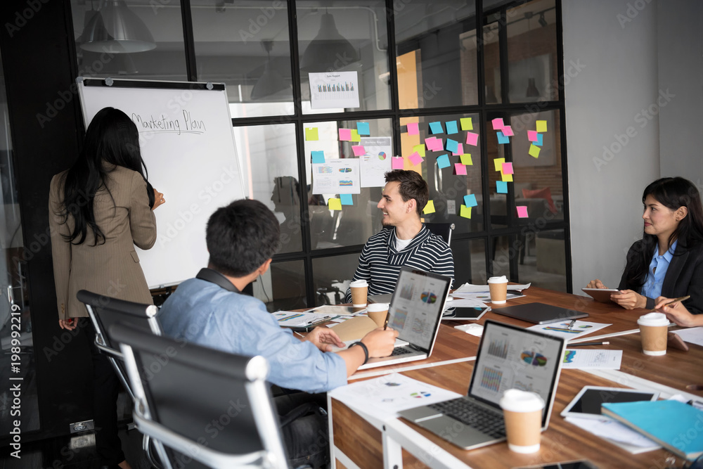 Group of young modern people in casual wear planning business strategy. Business team analyzing income charts and graphs. Setup studio shooting.