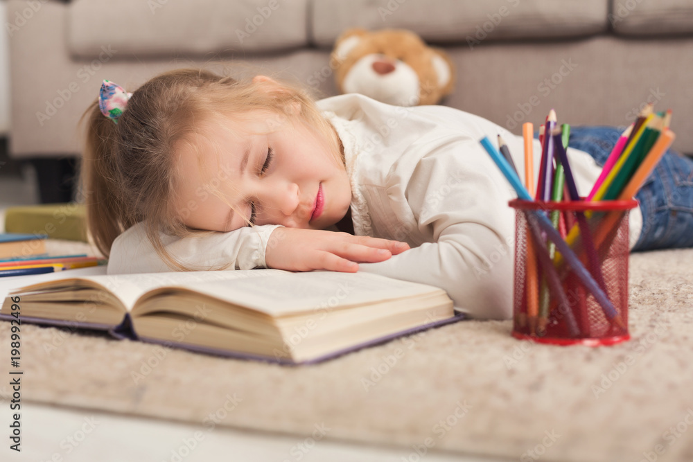 Cute little girl fell asleep while doing her homework. Cute little girl fell asleep while doing her homework.