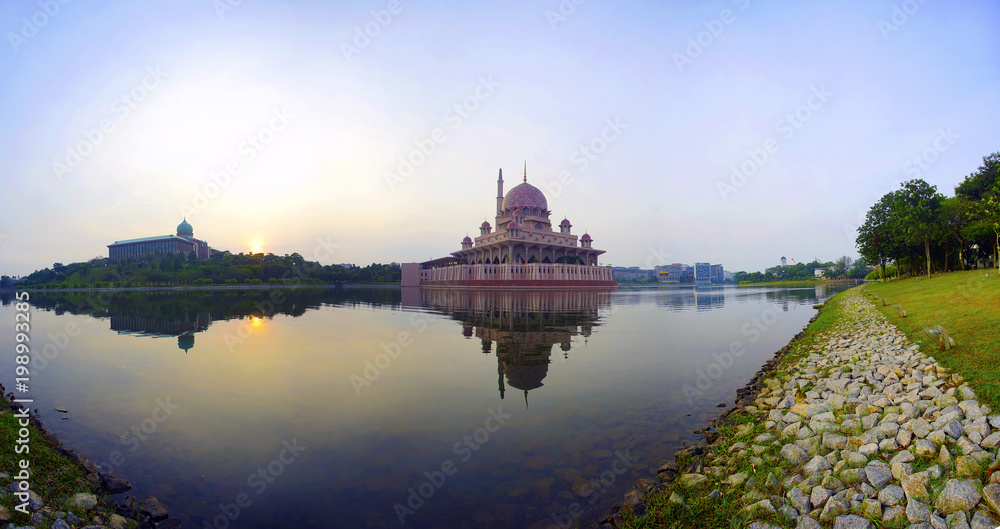 Superlarge megapixel Panoramic view of majestic mosque during sunrise with mirror reflection in the lake.