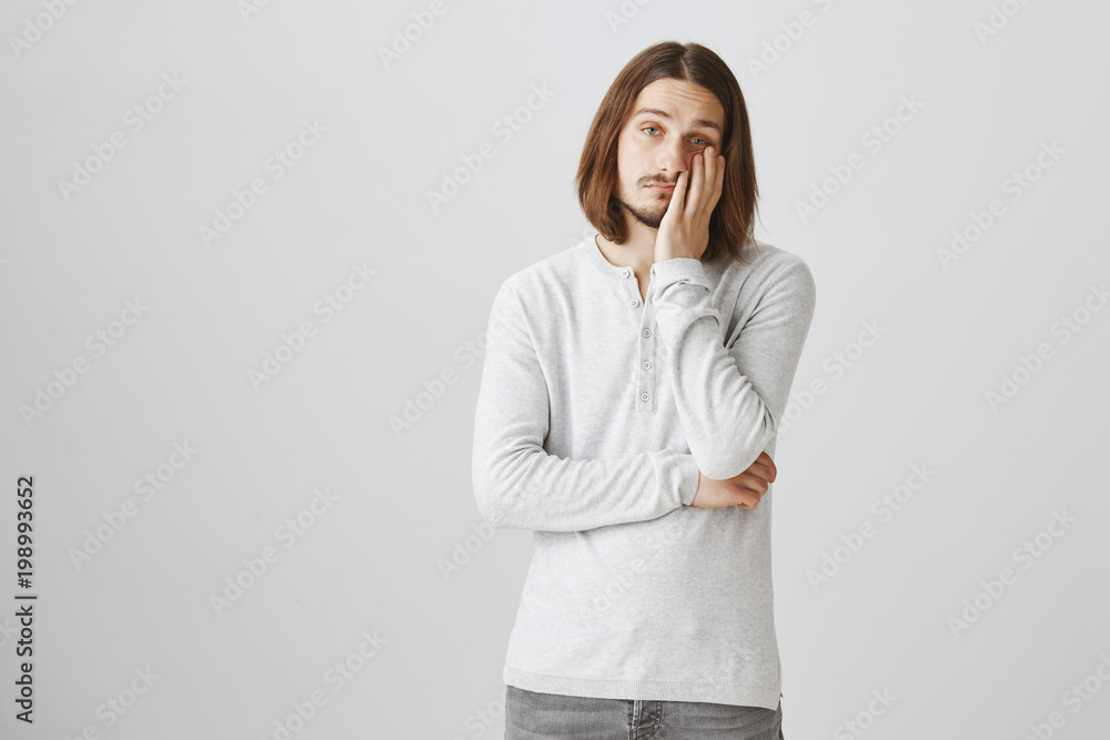 Guy is ready to sleep while standing. Portrait of tired handsome caucasian man leaning head on palm, being bored and uninterested, wanting to escape from boring meeting, looking indifferent at camera Guy is ready to sleep while standing. Portrait of tired handsome caucasian man leaning head on palm, being bored and uninterested, wanting to escape from boring meeting, looking indifferent at camera