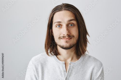 Pleasant attractive actor interviewing for new movie. Waist-up portrait of friendly good-looking male with beard and moustache smiling and expressing positive attitude, talking casually