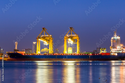 Shipping working loading containers by crane in ship on the night