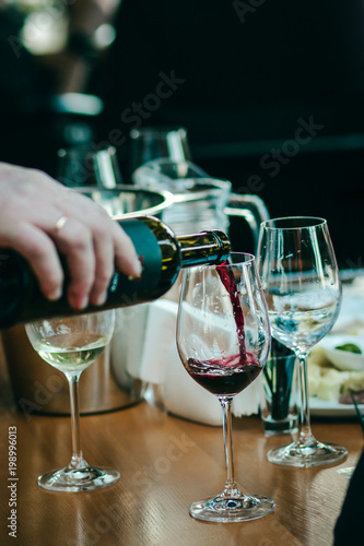 Wallpaper Mural Sommelier pouring red wine in a glass at a restaurant table Torontodigital.ca