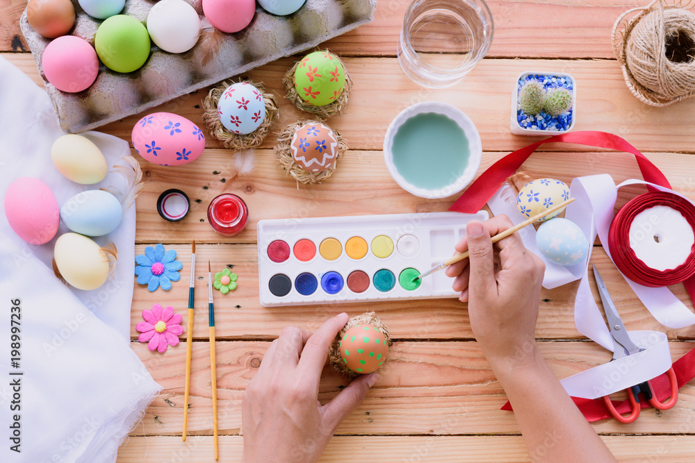 Happy easter! A woman hand painting Easter eggs. Happy family preparing for Easter. Happy easter! A woman hand painting Easter eggs. Happy family preparing for Easter.