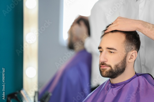 Professional hairdresser working with client in salon