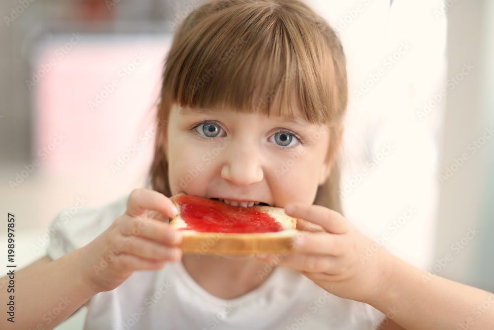 Cute little girl eating toast with jam at home Cute little girl eating toast with jam at home