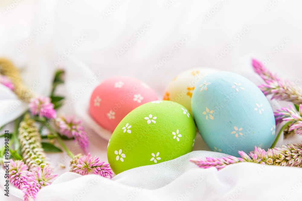 Happy easter! Colorful of Easter eggs in nest with flower, paper star and Feather on white cheesecloth background. Happy easter! Colorful of Easter eggs in nest with flower, paper star and Feather on white cheesecloth background.