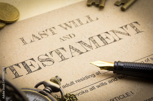 Close up view of Black pen, Gold coins, Keys and vintage clock on Last will and testament document concept