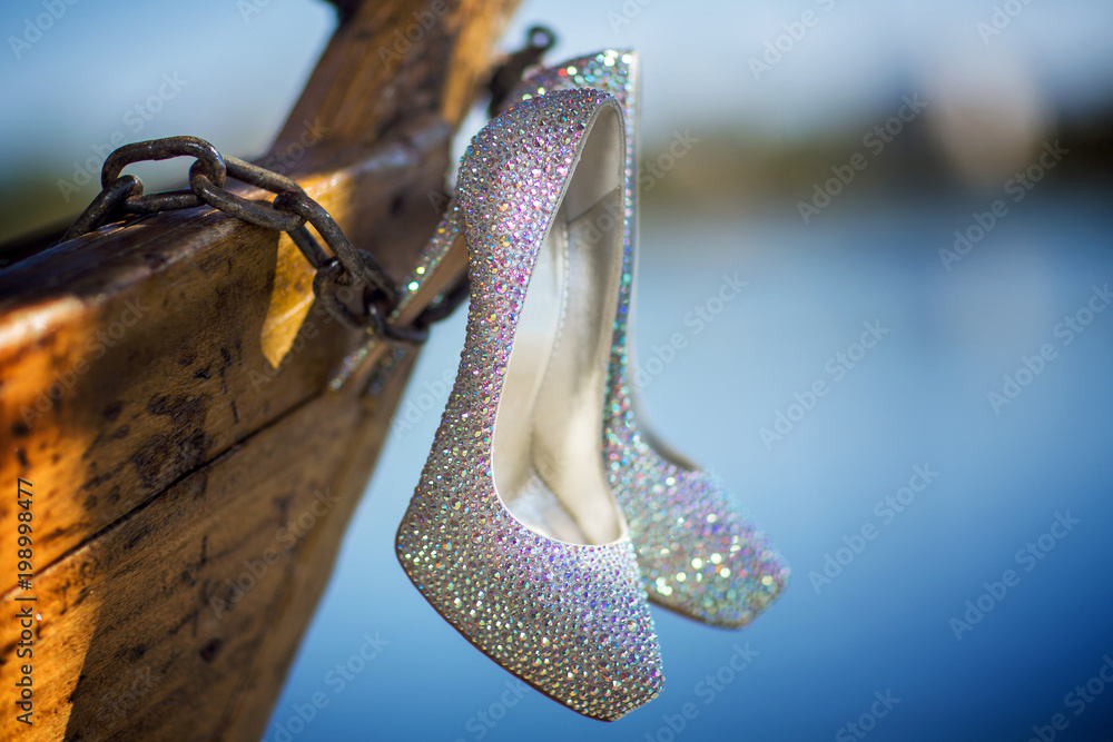Naklejka premium Closeup detail of bridal high heeled platform stiletto wedding shoes with flower bouquet.
