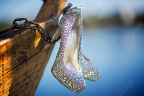 Closeup detail of bridal high heeled platform stiletto wedding shoes with flower bouquet. photo