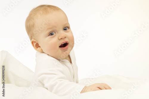 bright portrait of adorable baby boy on the blue background