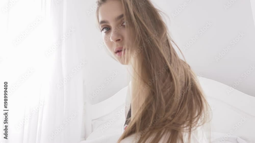 Sensual sexy caucasian blonde woman in black lace lingerie looking at the camera, play with her hair, portrait, temptation, white sunlight in the background 60 fps Sensual sexy caucasian blonde woman in black lace lingerie looking at the camera, play with her hair, portrait, temptation, white sunlight in the background 60 fps
