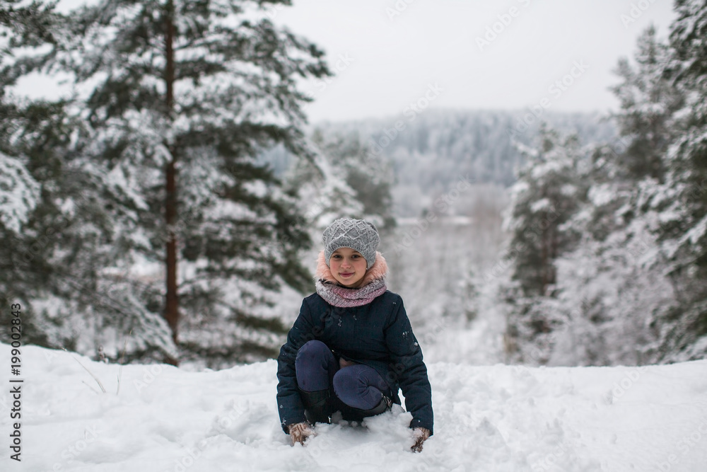 Little girl in the winter snowy Park.