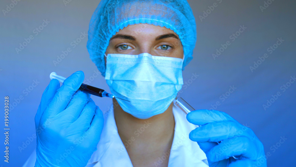 Young beautiful woman, nurse, doctor, wearing a mask, cap, syringe, tests, DNA, blue rubber gloves, white blue background. Young beautiful woman, nurse, doctor, wearing a mask, cap, syringe, tests, DNA, blue rubber gloves, white blue background.