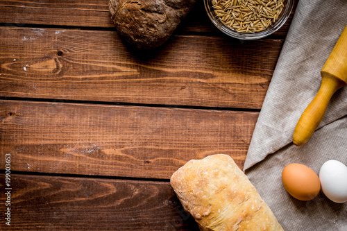 Baking homemade bread on wooden background top view moke up photo