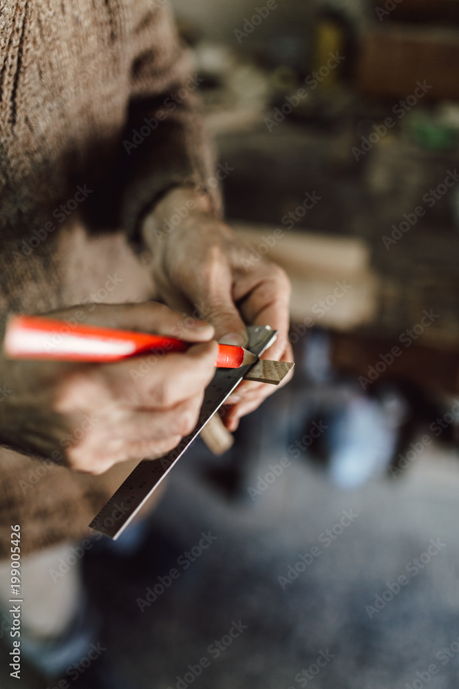 Obraz premium Close up shot of old master carpenter working in his woodwork or workshop