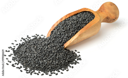 Canvastavla dried black sesame seeds in the olive wooden scoop, isolated on white